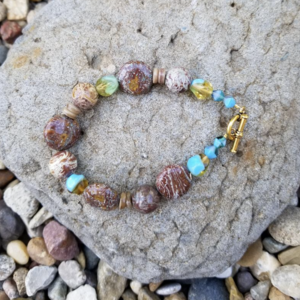 Beaded blue and brown bracelet with gold toned toggle closure. is being swapped online for free